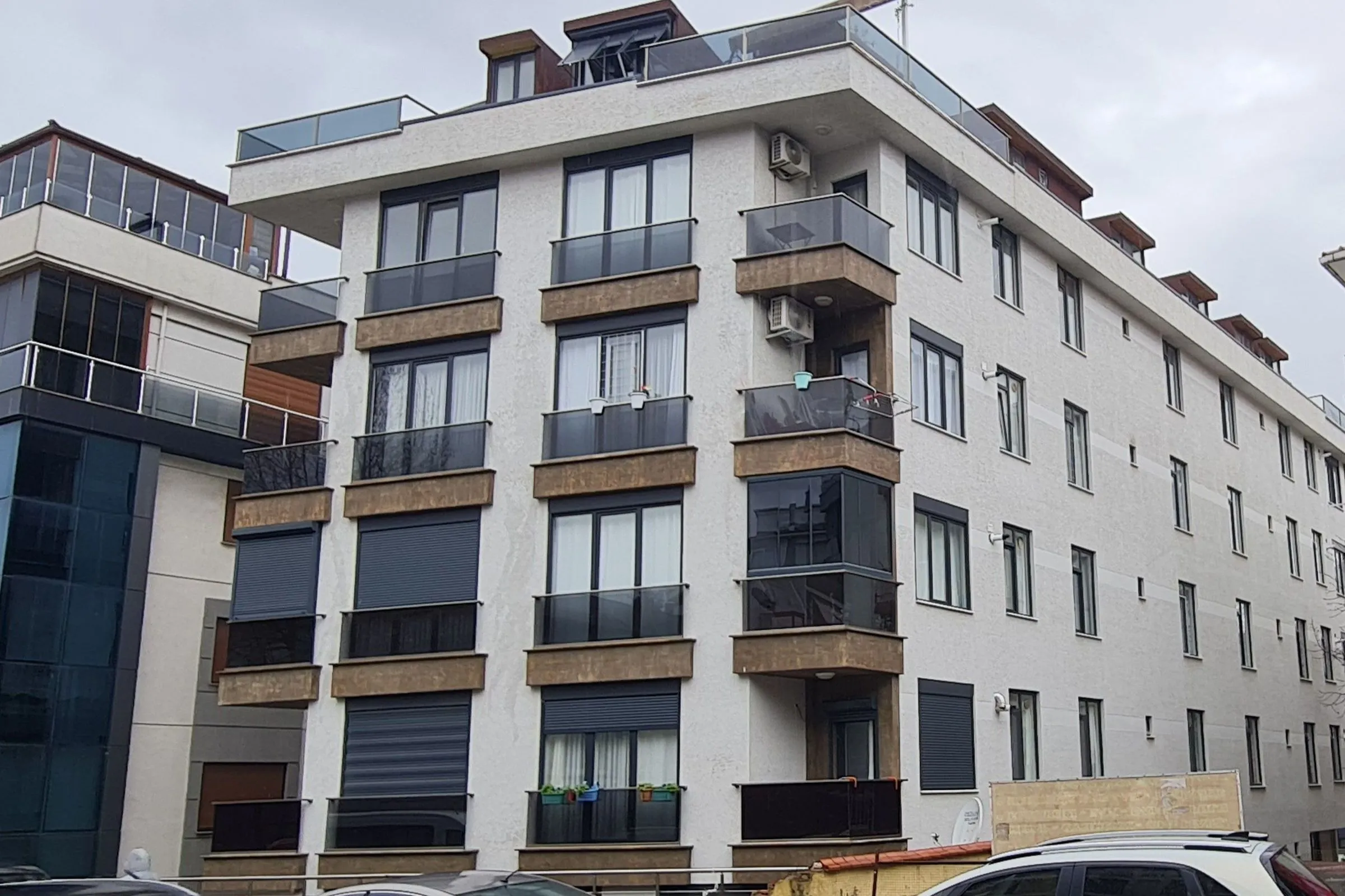 İdealtepe’de Çamlık Apartmanı: bronz tonlu balkon alınlıkları, füme cam korkuluklar ve teraslı çatı katı olan konut cephesi