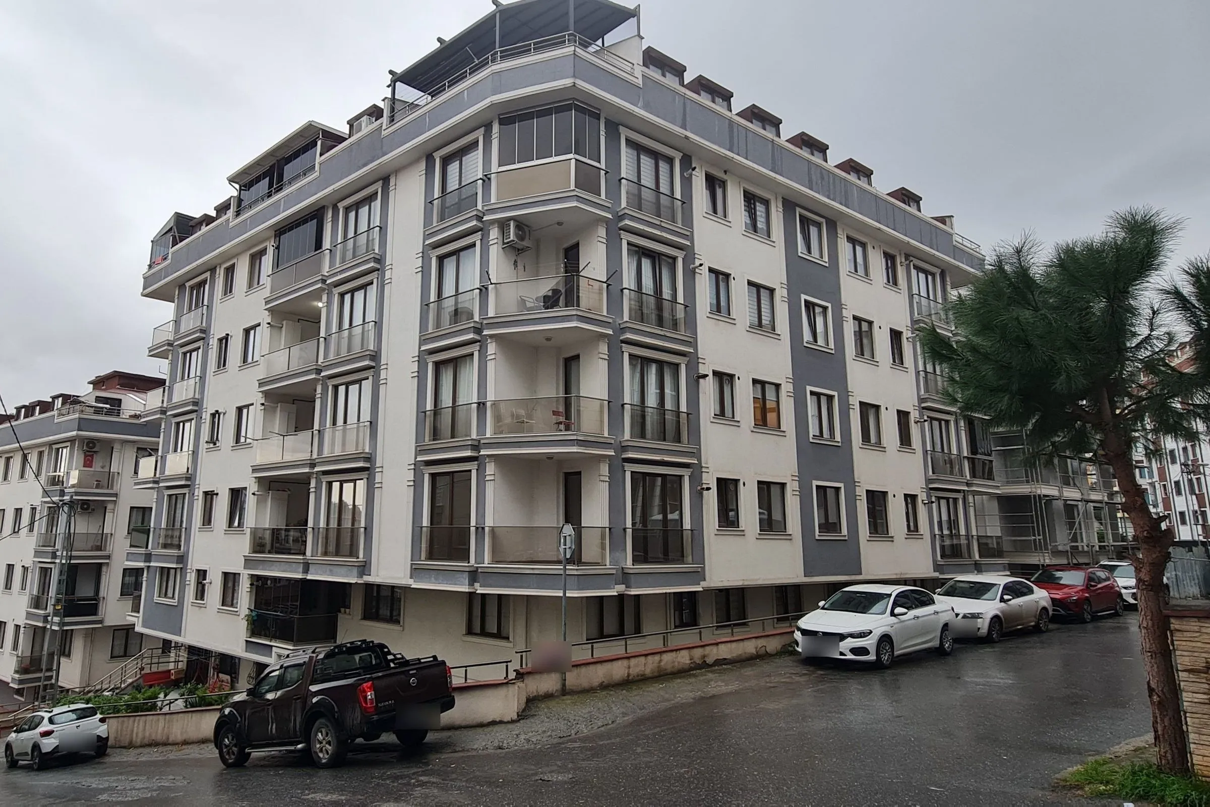 Girne Residences in Girne, Maltepe: a large residential complex with a cream façade, grey bands, roof terraces and dormer windows