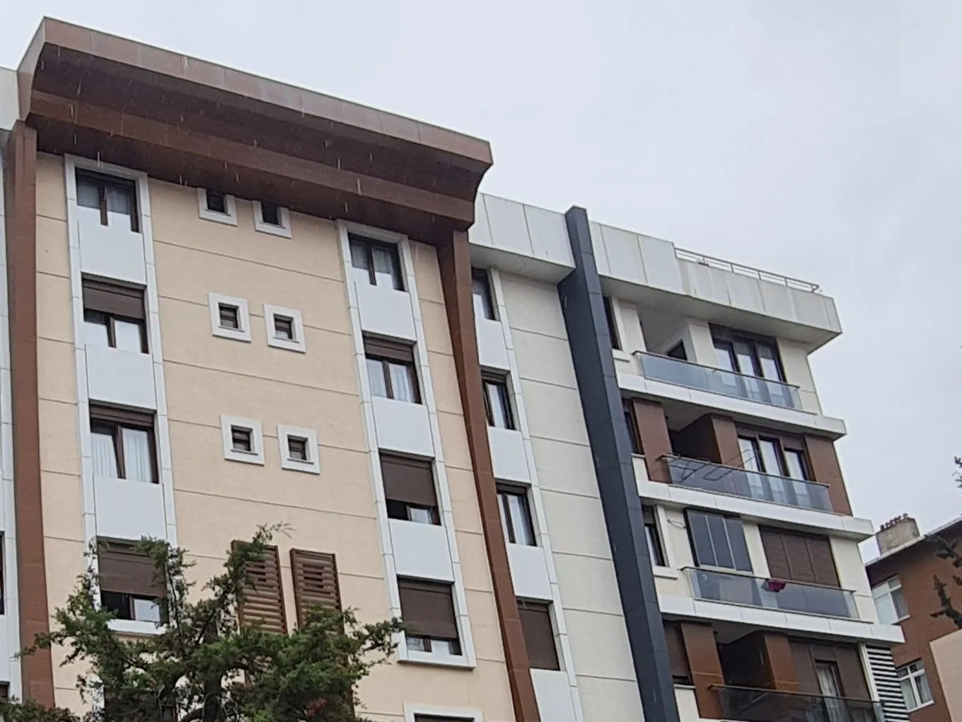 Tunç Apartmanı bronz saçak ve krem cephe detayı